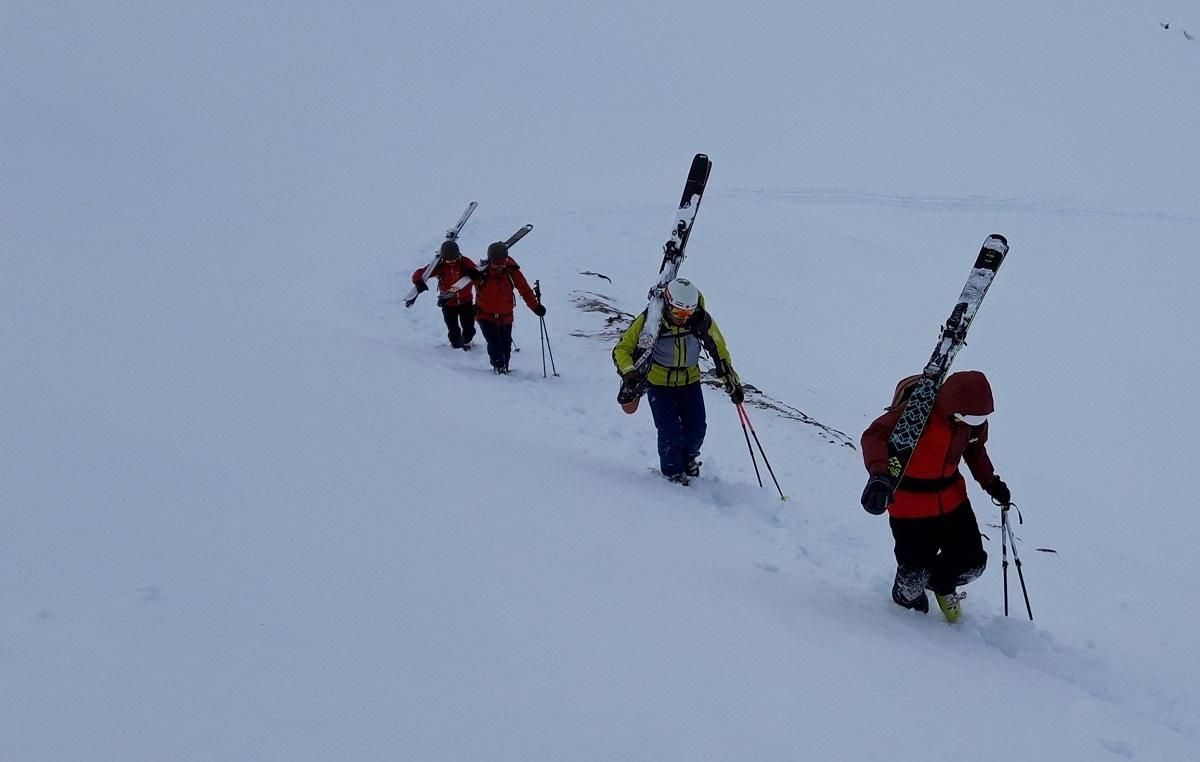 Die Teilnehmer tragen ihre Ski auf den Stubaier Gletscher 